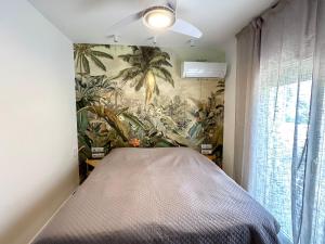 a bedroom with a bed with a mural of palm trees at Leto beach house in Limassol