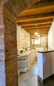 a kitchen with white cabinets and a brick wall at Casal del pigno in Peschiera del Garda