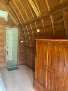 a room with a wooden ceiling and a bathroom at Kelingking Tatakan Bungalow in Nusa Penida