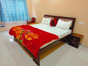 een slaapkamer met een bed met een rode deken bij Saryu Lodge near Ram Janam Bhumi in Ayodhya