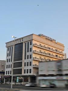 duży budynek z ciężarówką przed nim w obiekcie Jiwar Hotel w mieście Dżudda
