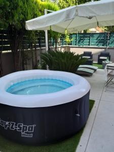 einen großen Whirlpool im Hof mit Sonnenschirm in der Unterkunft Marini Bed&Breakfast in Pescara