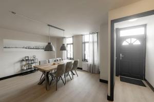 comedor con mesa, sillas y puerta negra en Dijkwoning 7 personen Yerseke Zeeland, en Yerseke