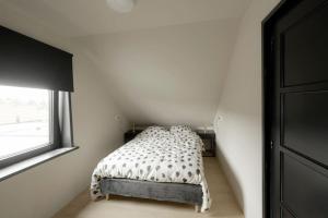 1 dormitorio con 1 cama en una habitación con ventana en Dijkwoning 7 personen Yerseke Zeeland, en Yerseke