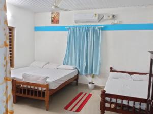 a room with two beds and a window at Lake Homes in Varkala