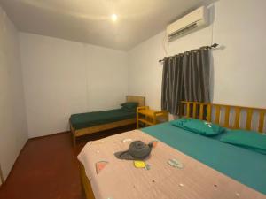 una piccola camera con due letti e una camera con un letto di una piazza di Sunset Homestay by Harry & Mimin a Telaga