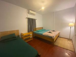 a small room with two beds and a fan at Sunset Cottages by Harry & Mimin in Telaga