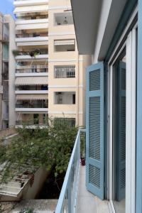 a balcony with a blue door and a building at Cozy Cityscape Apartment in Athens in Athens