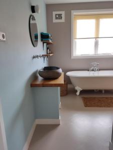 La salle de bains est pourvue d'une baignoire et d'un lavabo. dans l'établissement Sfeervolle woning dichtbij centrum Deventer, à Deventer