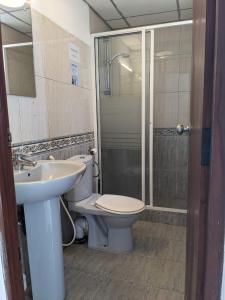 a bathroom with a toilet and a sink and a shower at Palmyrah Residencies in Colombo