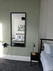 a bedroom with a bed and a mirror on the wall at Rectory5 - 5 bedroom 7 beds Parking Perfect for Contractors in Gateshead