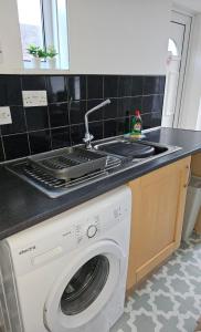 cocina con fregadero y lavadora en Rectory5 - 5 bedroom 7 beds Parking Perfect for Contractors, en Gateshead