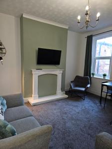 sala de estar con TV y chimenea en Rectory5 - 5 bedroom 7 beds Parking Perfect for Contractors, en Gateshead