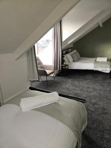una habitación de hotel con 2 camas y una silla en Rectory5 - 5 bedroom 7 beds Parking Perfect for Contractors, en Gateshead