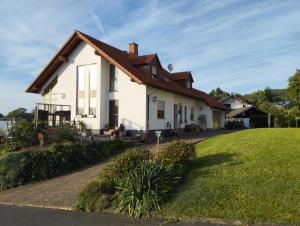 a white house with a red roof at Ferienwohnung Hilderser Auszeit in Hilders