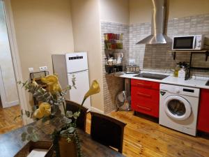 a kitchen with red cabinets and a washer and dryer at Good Morning...princeSa in Valladolid