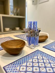 a table with bowls and utensils on a table at TATA Rio de Goa ,Good Stay Premium 2 BHK Apartment,6 km from Airport, - 101 in Dabolim