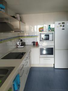 uma cozinha com armários brancos e um frigorífico branco em Frontal Las Terrazas 1 en Marina d`Or em Oropesa del Mar