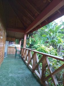 einen Balkon eines Hauses mit einem Tisch und Stühlen in der Unterkunft Berkey's Jungle Paradise Resort in Roseau