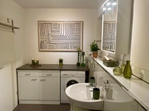 une salle de bain avec un lavabo et une machine à laver dans l'établissement 40qm Wohlfühl-Apartment im Grünen mit Sorglospaket, à Wuppertal 25 autres photos