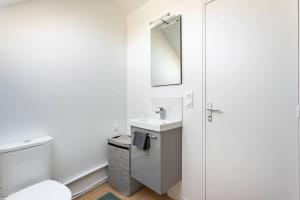 a white bathroom with a sink and a mirror at Au Bord du Canal 4E *Paris*Disney*Wifi* in Chelles