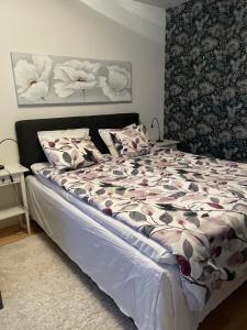 ein Schlafzimmer mit einem großen Bett mit Blumen darauf in der Unterkunft Peaceful City Centre Apartment (2 Bdr) in Rovaniemi