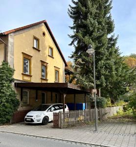 biały samochód zaparkowany przed domem w obiekcie Großzügiges Apartment im Loft-Stil w mieście Bad Berneck im Fichtelgebirge