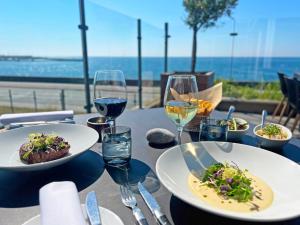 Griffen Spa Hotel في رونيه: طاولة مع أطباق من الطعام وكؤوس من النبيذ