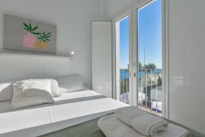 a white bedroom with a large white bed and a window at Bianca - by Almarina Villas in Teulada +69 photos