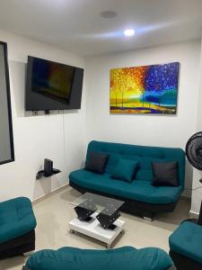 sala de estar con sofá azul y TV en hermoso apartamento, en Itagüí