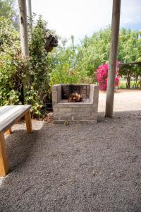 a brick fire pit with a bench next to it at De Rusty Farm in De Rust