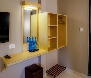 Una habitación con un estante con botellas azules. en Hotel Vinayaga Tiruppur, en Tirupur