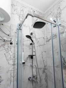 y baño con ducha y pared de mármol. en Hotel RAS Pazarište, en Novi Pazar