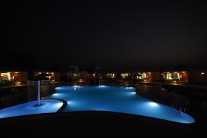 ein großer Swimmingpool in der Nacht mit Lichtern in der Unterkunft SKD RESORT AND CLUB 