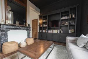a living room with a fireplace and a couch at Maison Comtale in Rochefort