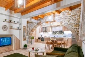 a living room and kitchen with a stone wall at Petros Luxury Traditional House - Villa in Kissamos