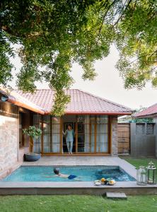 a woman standing in the doorway of a house with a swimming pool at Surpura Bagh in Jodhpur