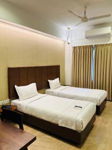 a hotel room with two beds and a window at Flora Embassy in Chennai