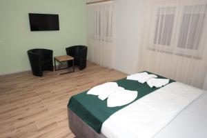 - une chambre avec un lit et des serviettes blanches dans l'établissement Swiss Apartmani, à Banja Luka