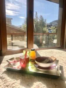 una bandeja con un plato de comida en una mesa con una ventana en ALIWEN Rauli en San Martín de los Andes