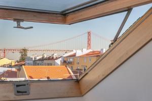 een raam met uitzicht op de gouden poortbrug bij Belém Sweet Spot in Lissabon