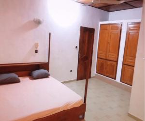 - une chambre avec un lit et une porte en bois dans l'établissement Guest house In benin, à Abomey-Calavi