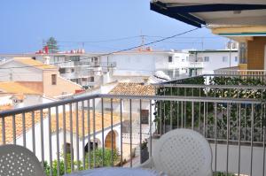ein Balkon mit Stühlen und Blick auf die Stadt in der Unterkunft APARTAMENTO 2 PAUPÍ in Oliva