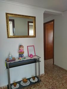 ein Tisch mit einem Spiegel und einer Puppe darauf in der Unterkunft APARTAMENTO 2 PAUPÍ in Oliva