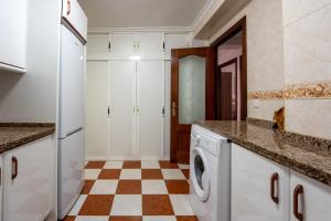 セビリアにあるSevilla Solの白いキャビネットとチェッカーフロア付きのキッチン