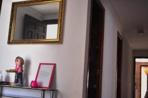 Eine Puppe sitzt auf einem Regal unter einem Spiegel. in der Unterkunft APARTAMENTO 2 PAUPÍ in Oliva