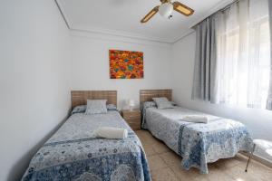 セビリアにあるSevilla Solのベッドが2つあり、壁に絵が飾られた寝室