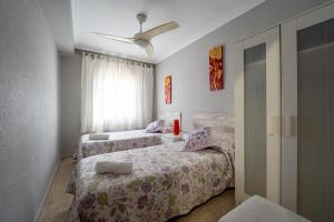 1 dormitorio con 2 camas y ventana en Sevilla Sol, en Sevilla