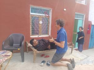 Due uomini che giocano con un uomo steso su un letto di Homes of India a Orchha