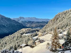 a snow covered mountain with a town and trees at Sonnige Panorama Aussicht bei Davos Lenzerheide in Schmitten